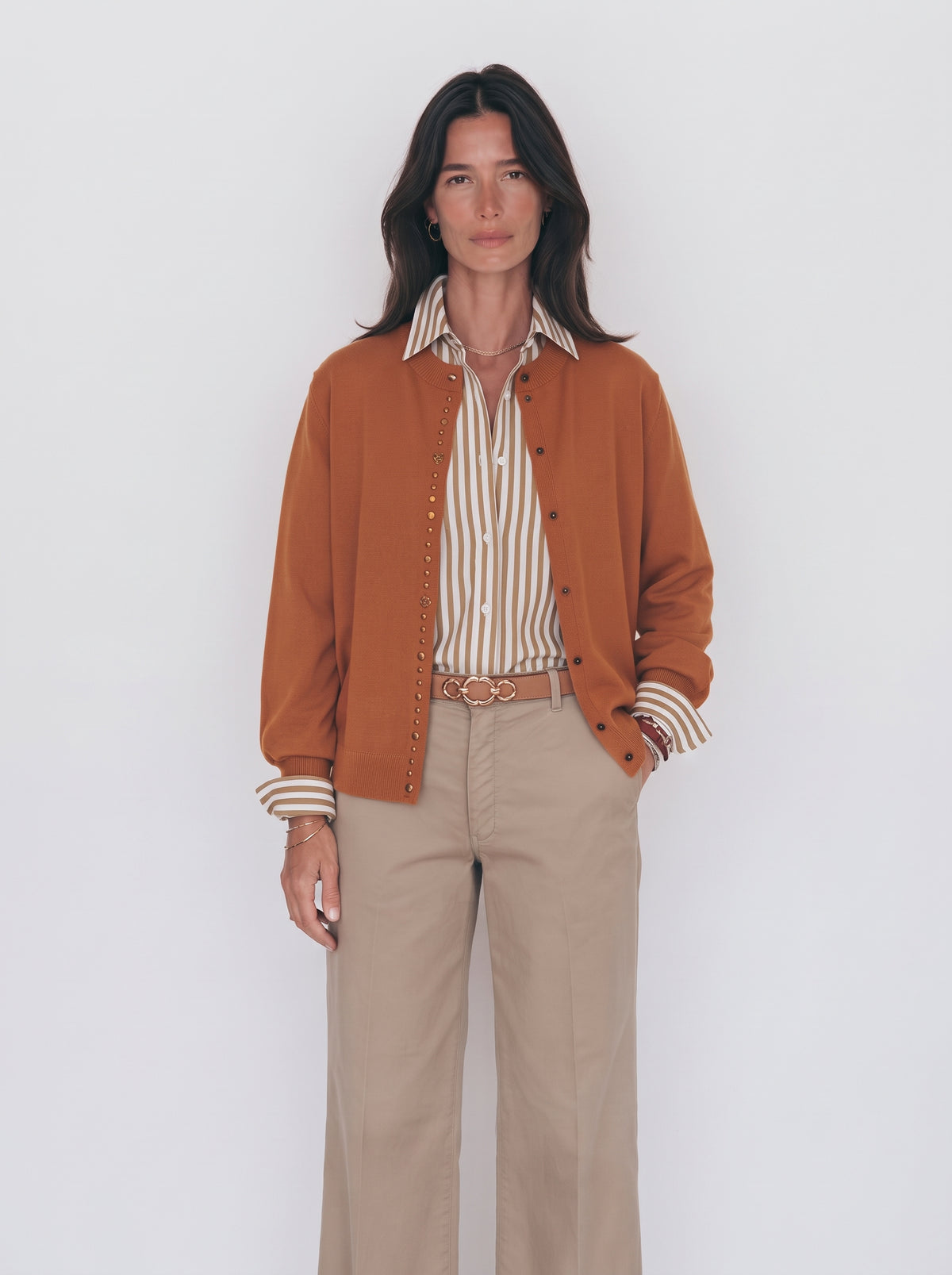 Rebeca mostaza con tachas para mujer sobre camisa de rayas y pantalón beige, plano medio