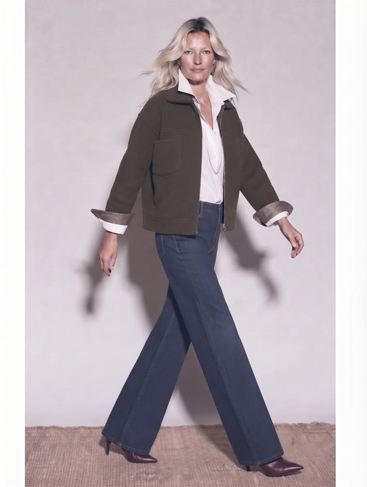 Chaqueta corta kaki con cremallera para mujer con camisa blanca y tejanos anchos, caminando