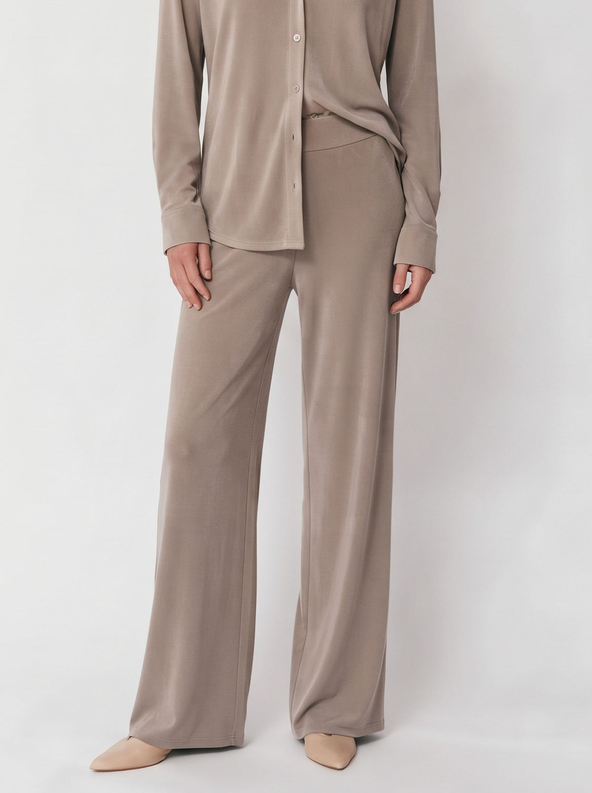 Camisa camel por fuera con pantalón ancho a juego y zapatos beige, encuadre de cintura a pies