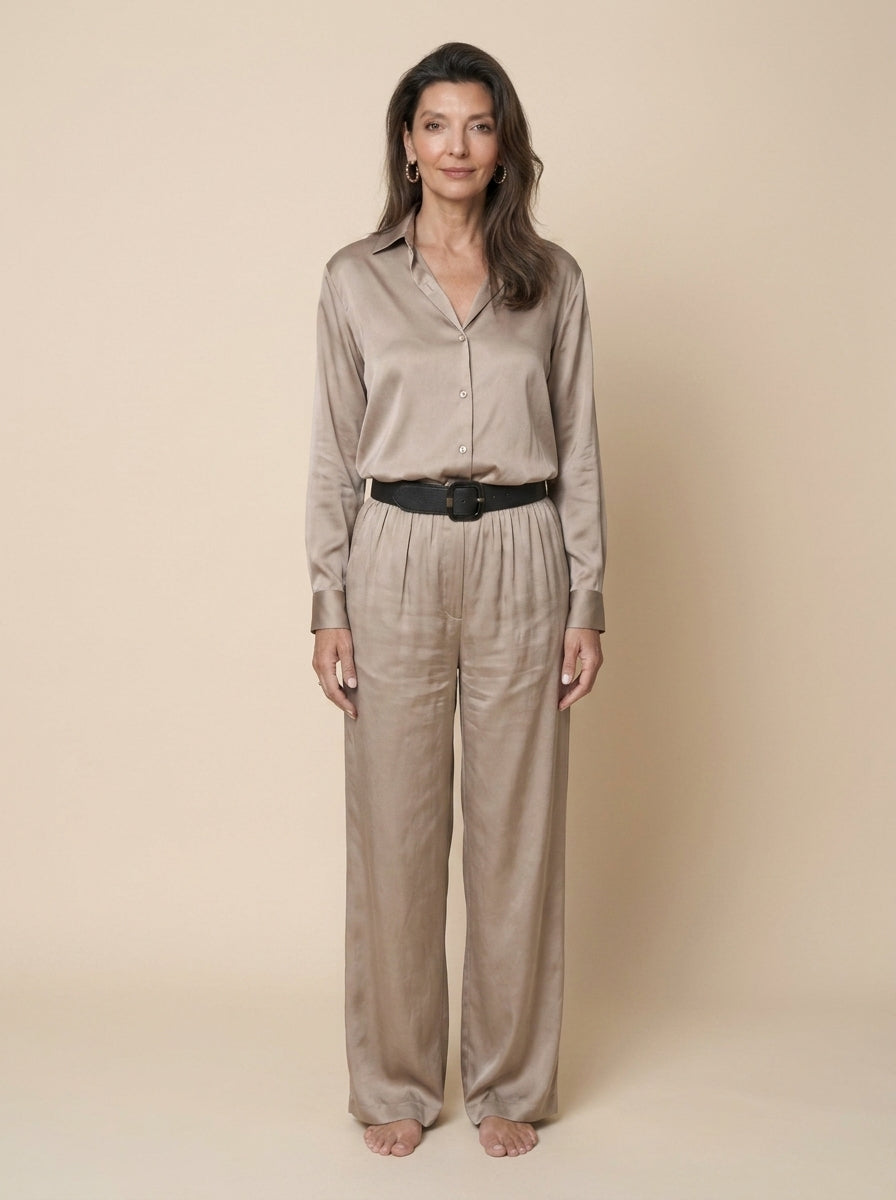 Camisa de raso beige con pantalón ancho a juego y cinturón negro, cuerpo entero de frente