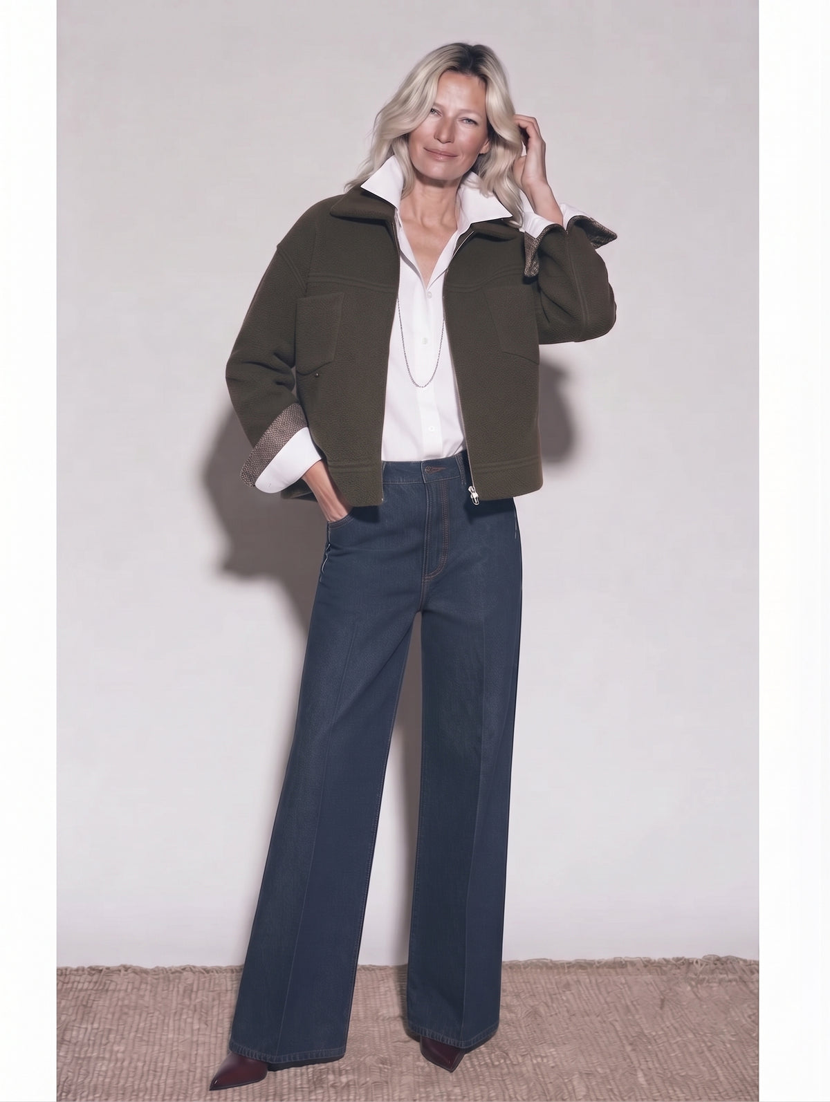 Chaqueta corta kaki con puños vueltos, camisa blanca y tejanos oscuros, cuerpo entero