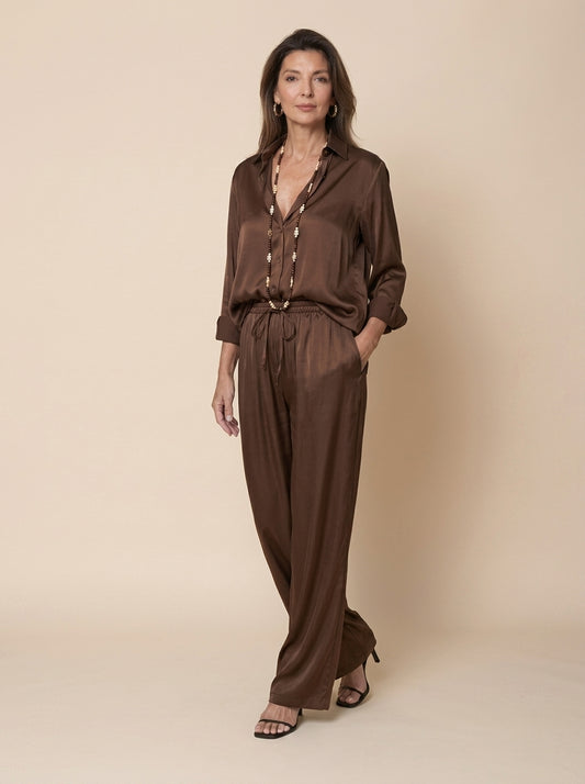 Pantalón palazzo de raso marrón para mujer con camisa a juego y collar largo, cuerpo entero