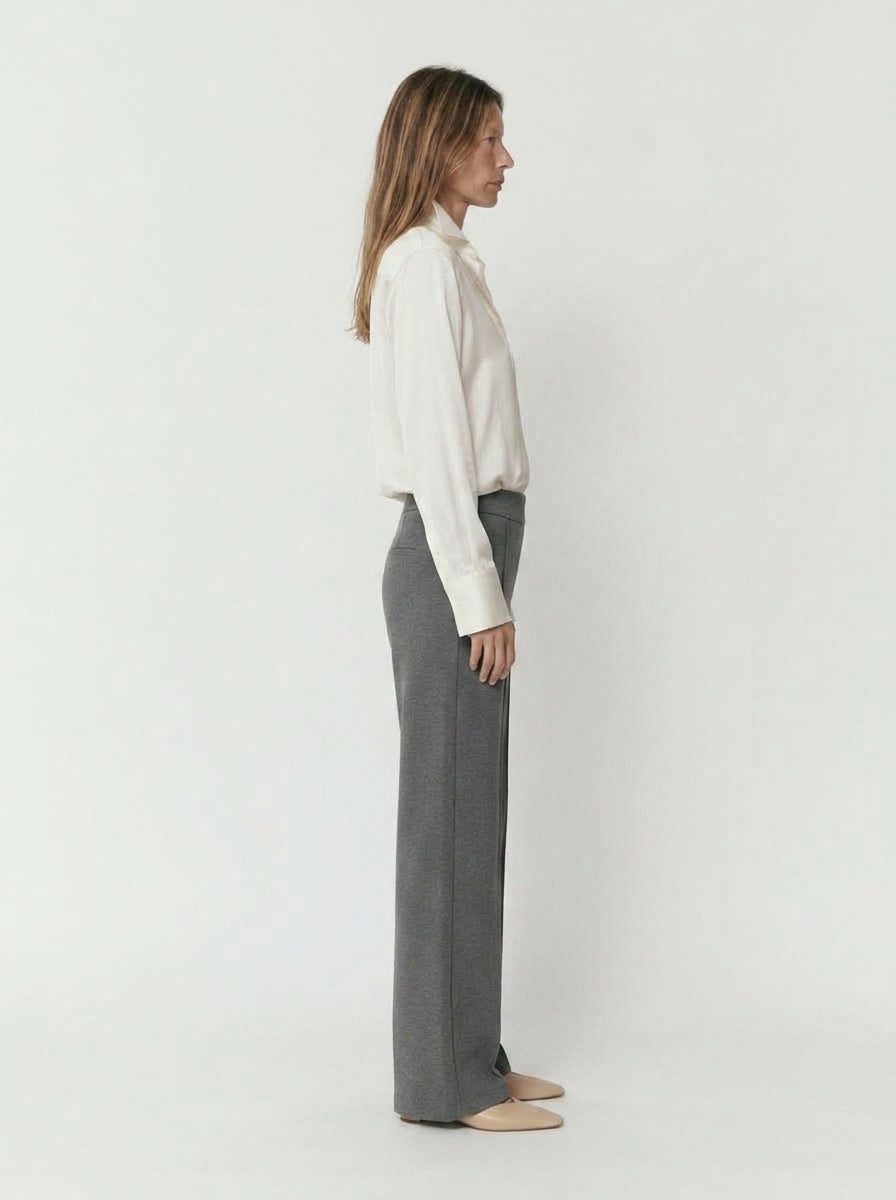 Pantalón gris de pernera recta con camisa blanca remangada, vista de perfil de cuerpo entero