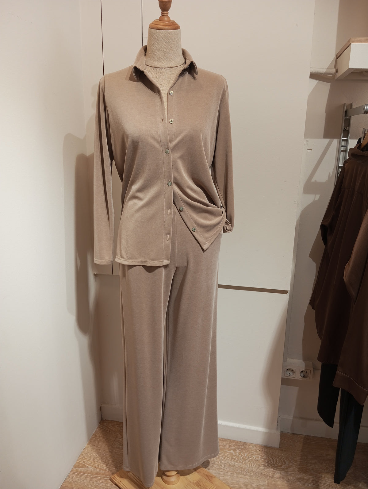 Pantalón fluido camel de pernera ancha con camisa a juego por fuera, en maniquí